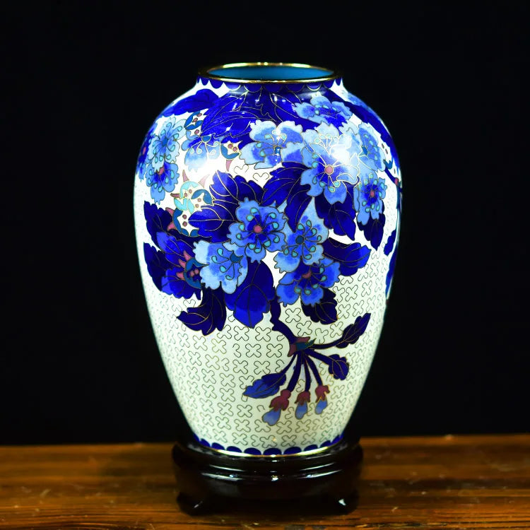 Vase en céramique orné de motifs floraux bleus et blancs sur fond noir.