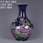 Un magnifique vase en céramique avec des fleurs de pivoines peintes en relief sur un fond bleu foncé, créant une scène élégante et traditionnelle.