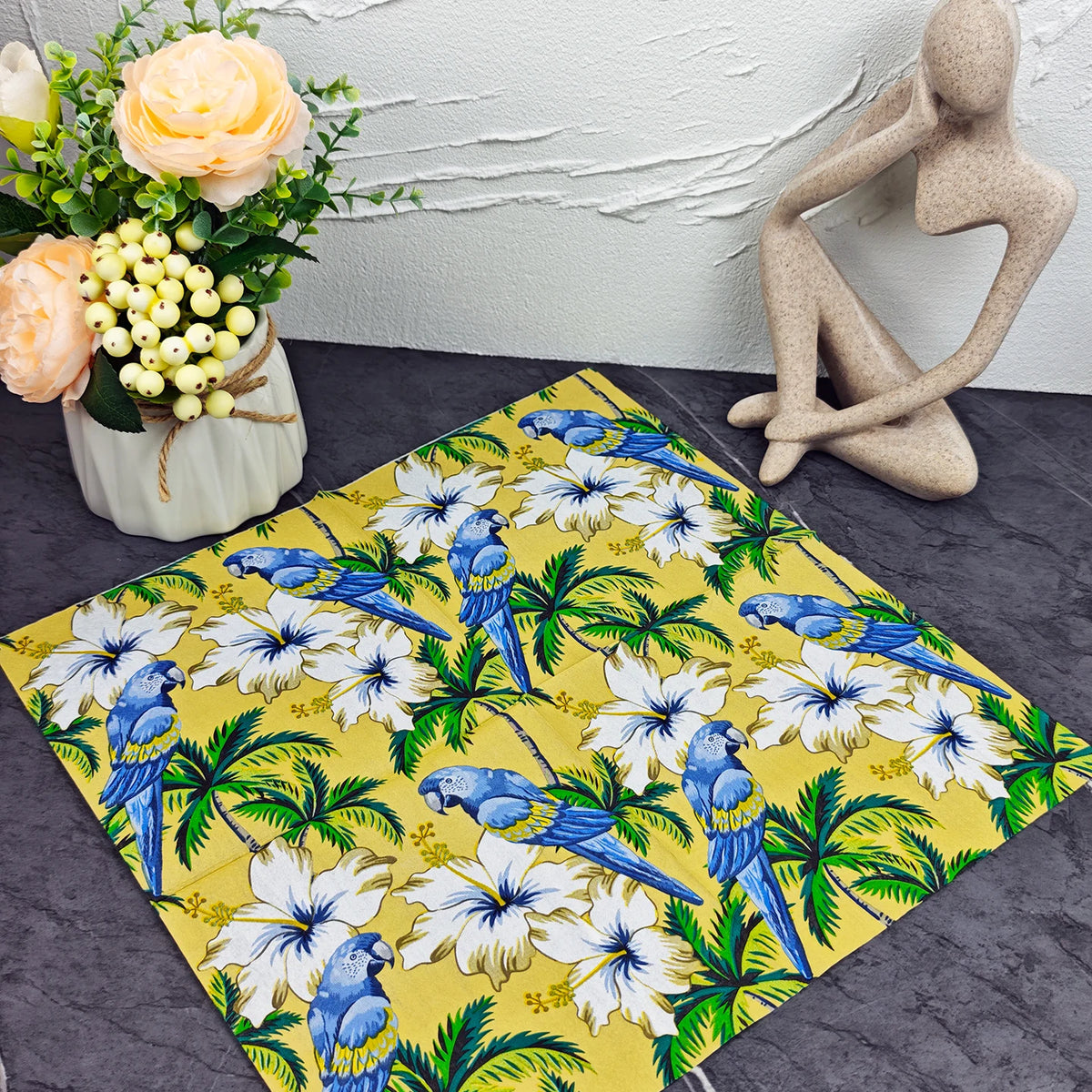 serviettes table papier motif tropical perroquets fleurs palmiers jaune bleu vert hibiscus pliées dépliées
