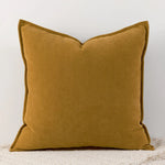 Coussin décoratif carré en velours doré, élégant et chic pour une décoration d'intérieur moderne.