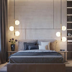 suspension lumineuse moderne sphères translucides barre métallique brillante blanc doré minimaliste chambre salon