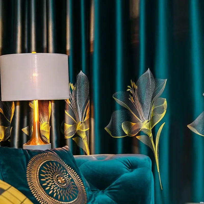 Lampe de table élégante avec un abat-jour blanc, posée près d'un canapé bleu richement décoré. En arrière-plan, des rideaux bleu foncé arborent des motifs floraux jaunes lumineux, créant une ambiance chaleureuse et moderne dans le salon. Accessoire idéal pour ajouter une touche de sophistication et de style à votre décoration intérieure.