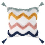 Oreiller décoratif blanc orné de motifs en zigzag dans des tons de gris, rose et bleu marine avec des pompons assortis.