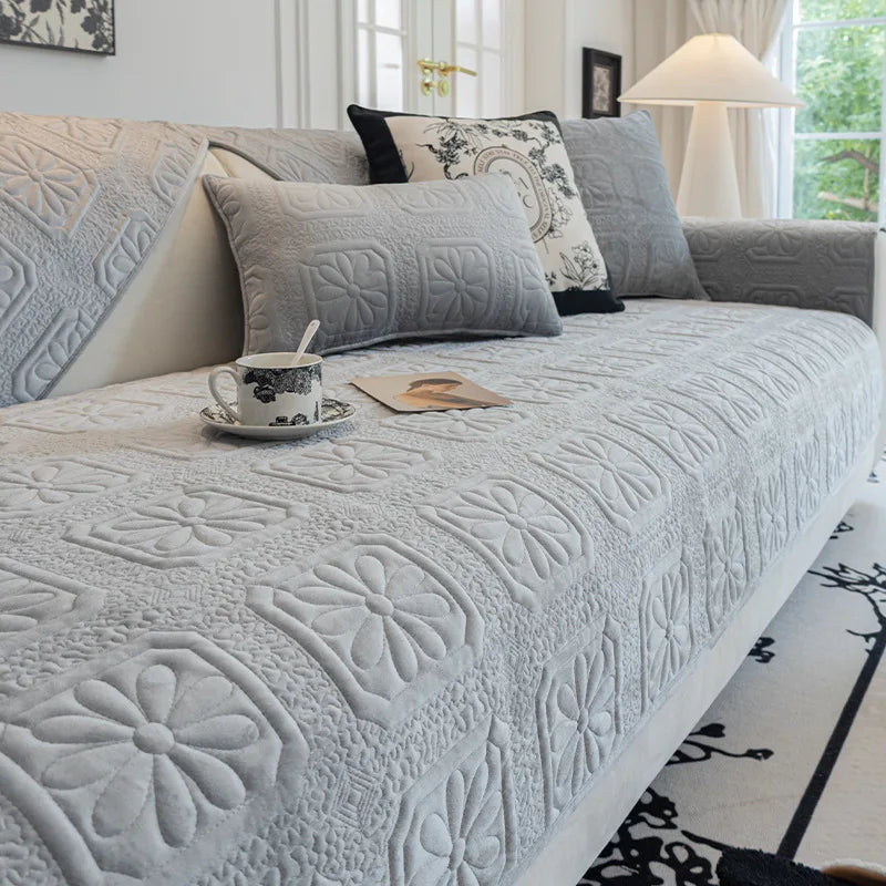 Un canapé confortable et douillet, avec des coussins décorés de motifs floraux et de textures luxueuses, offrant un endroit accueillant pour se détendre.