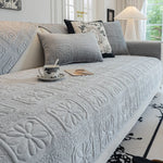 Un canapé confortable et douillet, avec des coussins décorés de motifs floraux et de textures luxueuses, offrant un endroit accueillant pour se détendre.