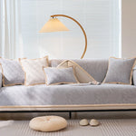 Un canapé confortable garni de coussins moelleux, éclairé par une lampe au design élégant, créant une atmosphère chaleureuse et apaisante dans un intérieur lumineux.