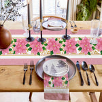 Jolie table de fête avec une vaisselle élégante, des bougies, des fleurs roses et des éléments décoratifs sur fond de fenêtre donnant sur l'extérieur.