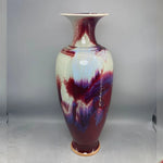 Magnifique vase en céramique émaillée dans des teintes de rouge, de violet et de bleu, aux couleurs vibrantes et aux motifs fluides, créant une œuvre d'art unique et captivante.