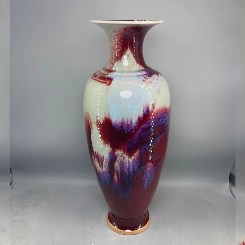 Magnifique vase en céramique émaillée dans des teintes de rouge, de violet et de bleu, aux couleurs vibrantes et aux motifs fluides, créant une œuvre d'art unique et captivante.