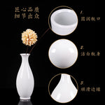 Vase blanc élégant avec une fleur d'or sur fond noir et informations techniques en chinois.