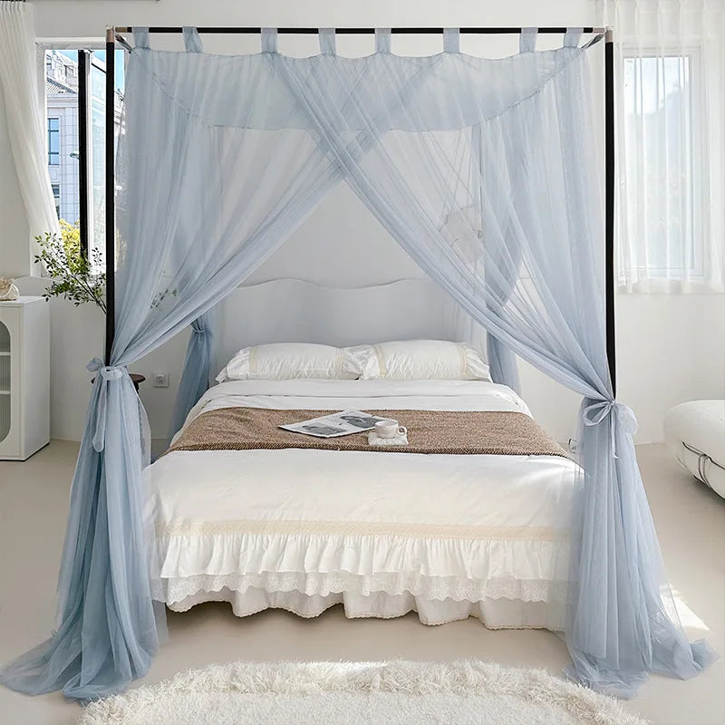 Chambre à coucher à thème romantique avec un lit à baldaquin, des rideaux aériens de couleur bleu clair et un couvre-lit blanc avec de la dentelle.
