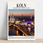 Cette image promotionnelle montre le paysage urbain nocturne de la ville de Cologne, en Allemagne. On peut y voir le célèbre dôme de la cathédrale de Cologne, ainsi que le pont ferroviaire Hohenzollern illuminé, surplombant le fleuve Rhin.