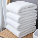 Serviette de bain blanche en coton épais pliée sur un porte-serviette