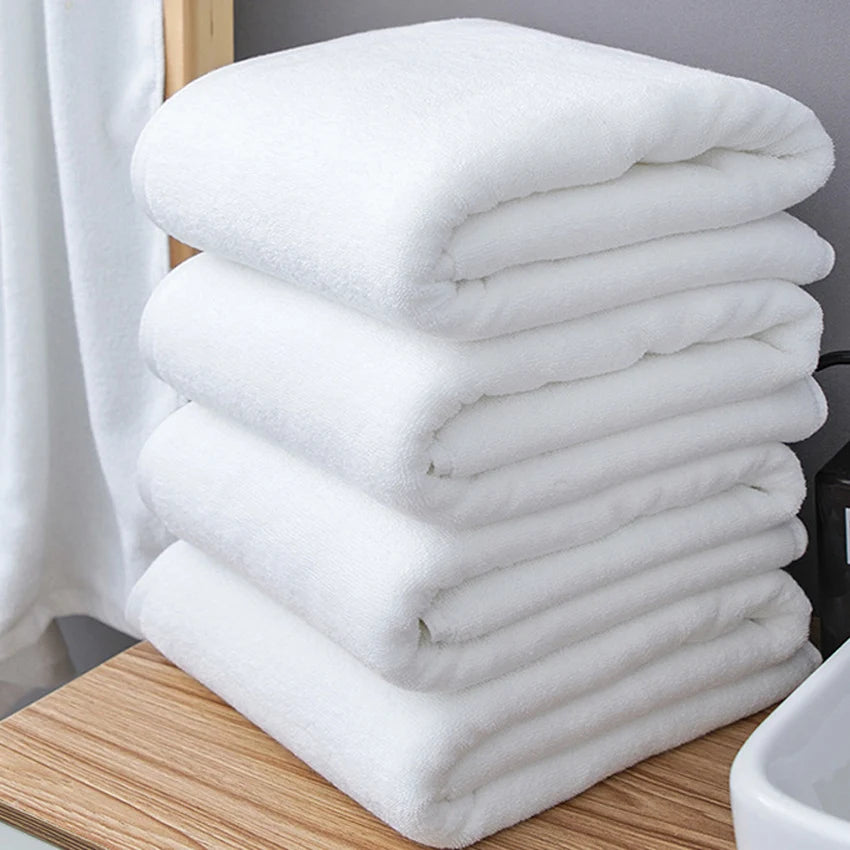 Serviette de bain blanche en coton épais pliée sur un porte-serviette