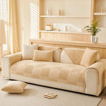 Le confortable canapé beige et blanc avec des coussins assortis est joliment positionné dans un salon lumineux et épuré, avec des étagères et des accessoires décoratifs élégants.