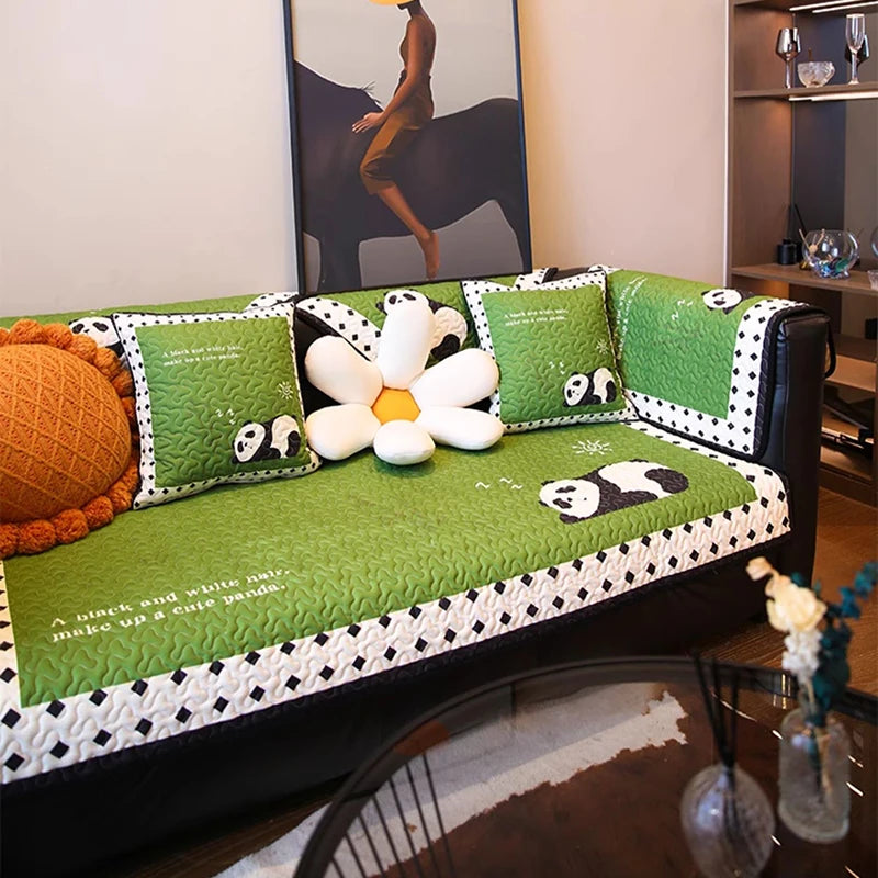 Un décor reposant avec des coussins verts motif panda et une fleur blanche décorative, créant une ambiance apaisante et ludique.