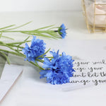 décoration intérieure bouquet fleurs artificielles bleues blanches roses longues tiges vertes vase transparent festonnée