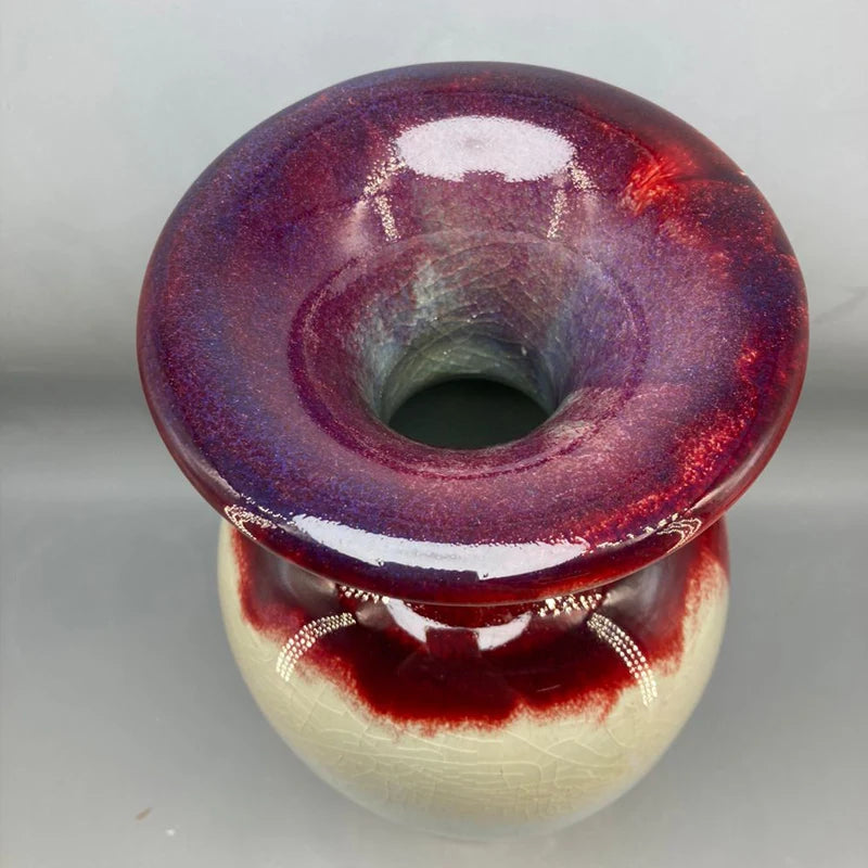Vase en verre irisé de couleur rouge et violet avec un design élégant et unique.
