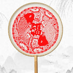 éventail artisanal traditionnel motifs floraux géométriques poignée bois pompon rouge soie tissée opacité festive