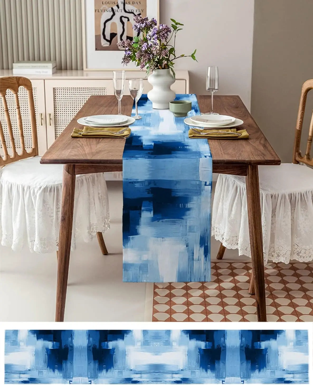 Une nappe de table en bleu abstrait décore cette salle à manger aux tons neutres, agrémentée de fleurs violettes dans un vase blanc.