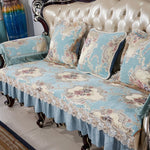 Élégant canapé de style victorien avec un motif floral délicat sur un fond bleu clair, orné de dentelle et de détails en bois ouvragé, créant une pièce d'ameublement de luxe et raffinée.