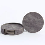 Ensemble de sous-verres ronds en bois de couleur grise avec un motif texturé.