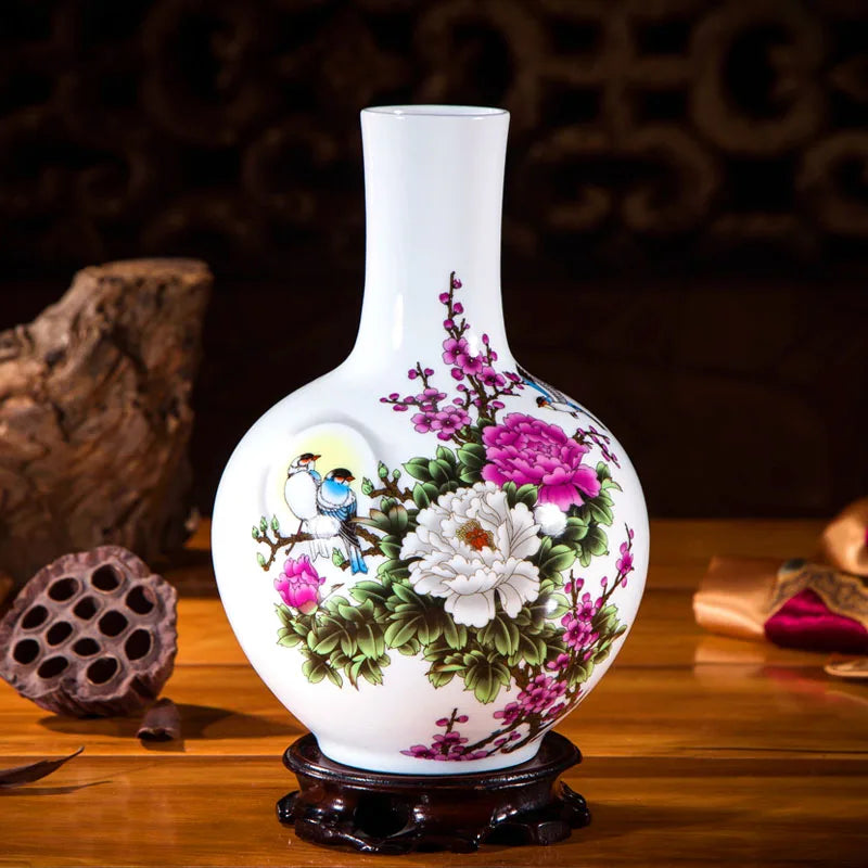 Vase en porcelaine avec motifs floraux colorés et un oiseau sur un support en bois sombre.
