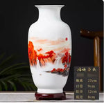 Vase en porcelaine blanche avec un motif de paysage montagneux aux couleurs chaudes.
