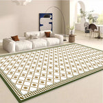 Ce tapis de sol élégant présente un motif géométrique orné de formes carrées et étoilées dans des tons de vert et d'or, créant une ambiance chaleureuse et sophistiquée dans cette pièce lumineuse dotée d'un canapé blanc et d'autres meubles modernes.