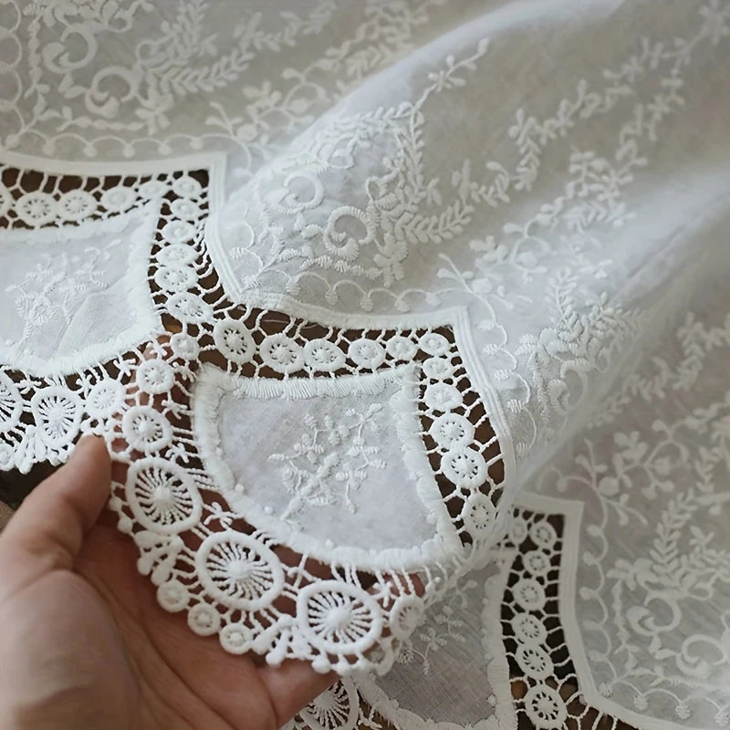 Détail de la dentelle brodée élégante du rideau blanc