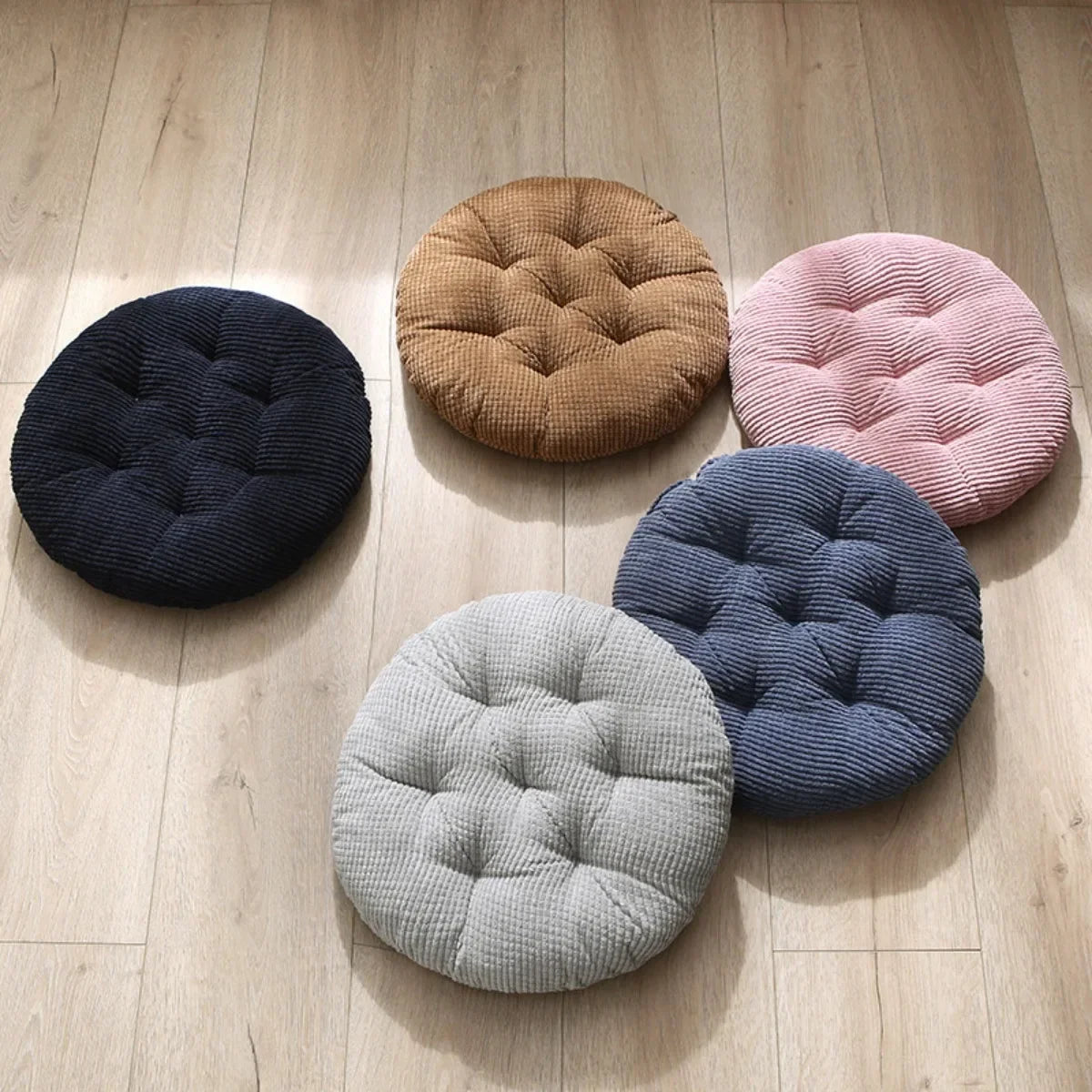 Coussin rond velours côtelé bourgogne sur sol salon
