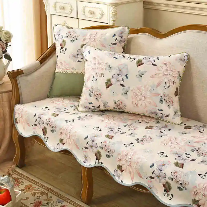 Un ensemble de literie floral et élégant, avec des motifs de fleurs pastel et délicats sur un fond blanc cassé, créant une atmosphère paisible et accueillante dans la chambre.