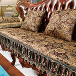 Élégant sofa capitonné aux motifs floraux dorés et ornements en bois sculpté, créant une atmosphère luxueuse et raffinée dans cette pièce.
