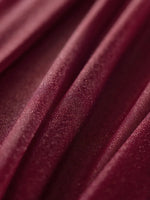 Riche et luxueuse texture de velours bordeaux avec des plis élégants.