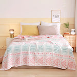 Une chambre élégante et accueillante avec des couleurs douces et des motifs géométriques sur la couverture, créant une atmosphère chaleureuse et apaisante.