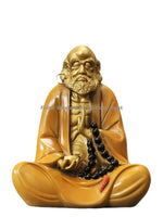 statue homme assis jaune doré rouge art bouddhiste traditionnel noires base bois sombre