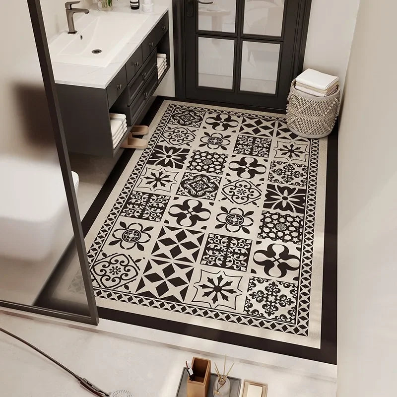 Carrelage noir et blanc décoratif dans une salle de bain moderne avec des motifs géométriques floraux.