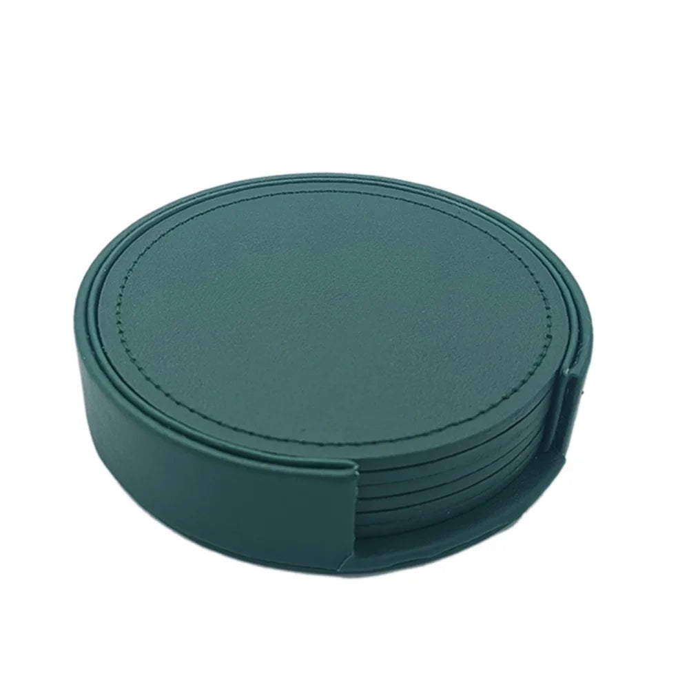 Sous-verres ronds en cuir vert foncé avec bordure piquée.