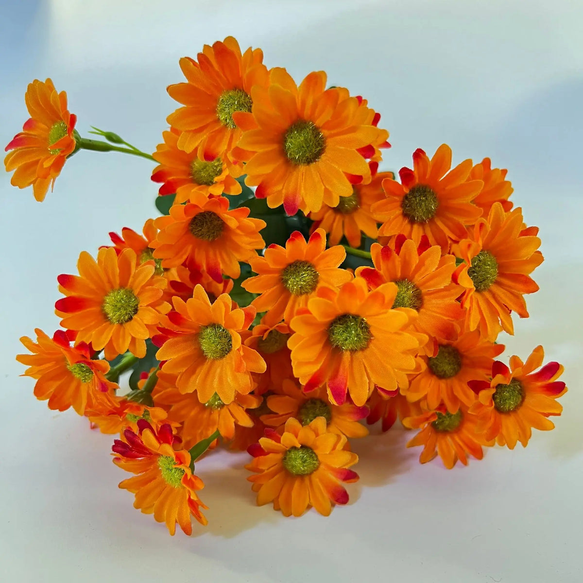 bouquets fleurs artificielles multiples pétales centre jaune vases noirs intérieur décoration mariage fêtes orangées