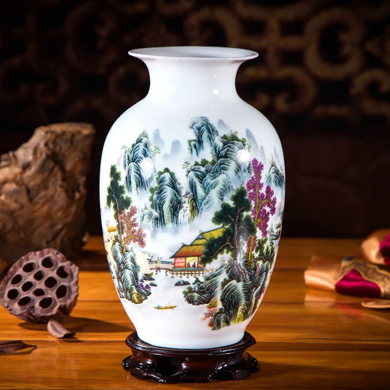 Un vase en porcelaine blanche décoré d'une scène de paysage montagneux avec une petite maison, des arbres et des rochers colorés.