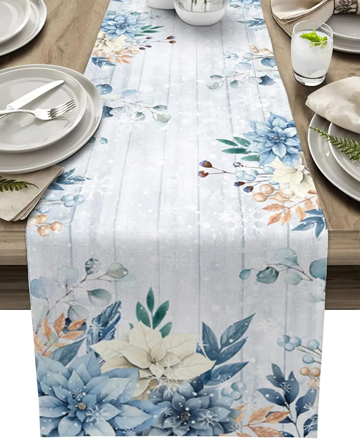 Une table dressée avec de magnifiques fleurs bleues et blanches sur un chemin de table délicat.