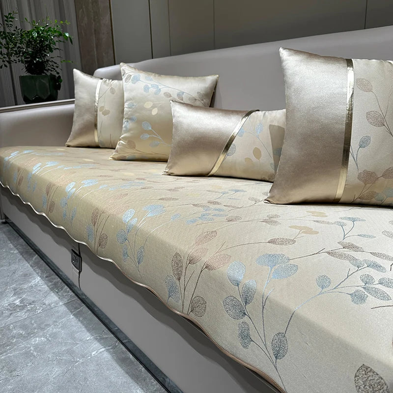 Cette image illustre un canapé élégant recouvert de coussins aux motifs floraux beiges, bleus et gris, qui crée une atmosphère chaleureuse et apaisante dans l'espace.