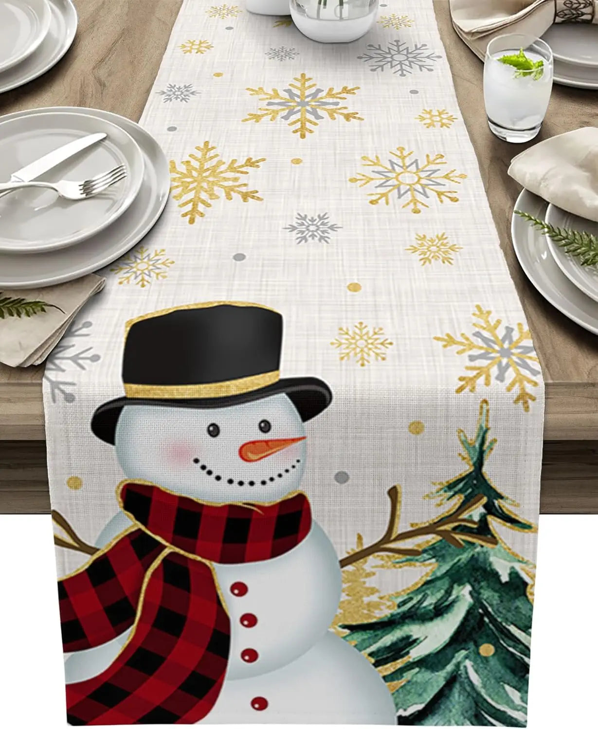 Une scène d'hiver festive avec un bonhomme de neige en tenue hivernale sur un chemin de table décoré de flocons de neige dorés.