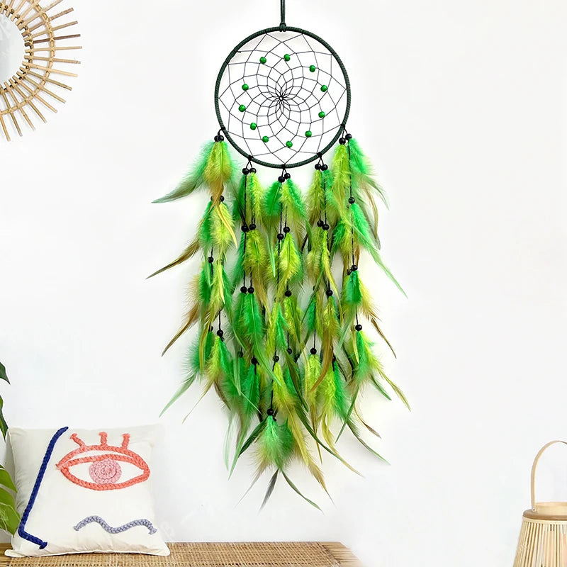Un attrape-rêves décoratif aux plumes vertes et jaunes avec des perles noires sur un anneau noir.
