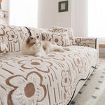 Un chat douillet est couché sur un canapé orné de motifs floraux.