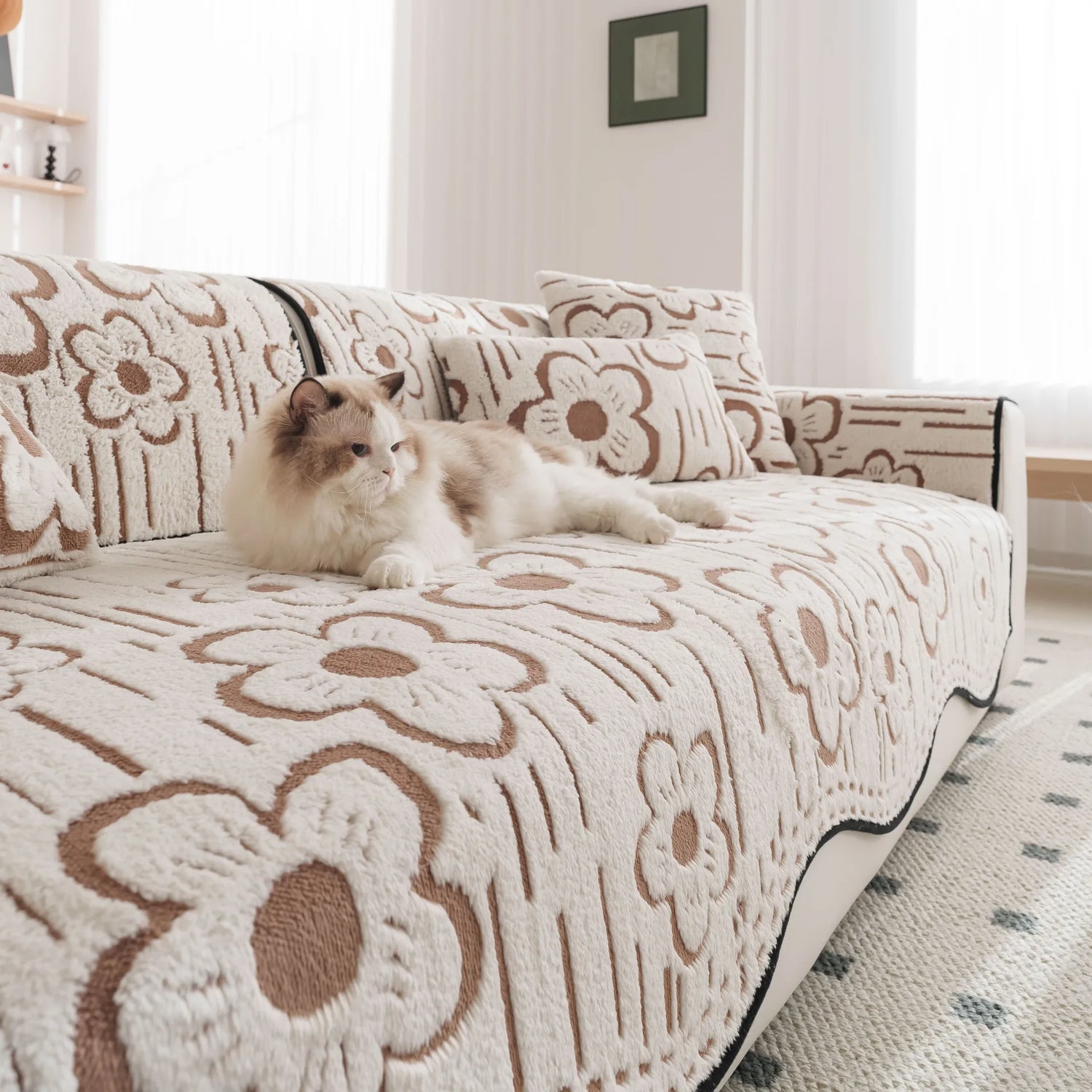 Un chat douillet est couché sur un canapé orné de motifs floraux.