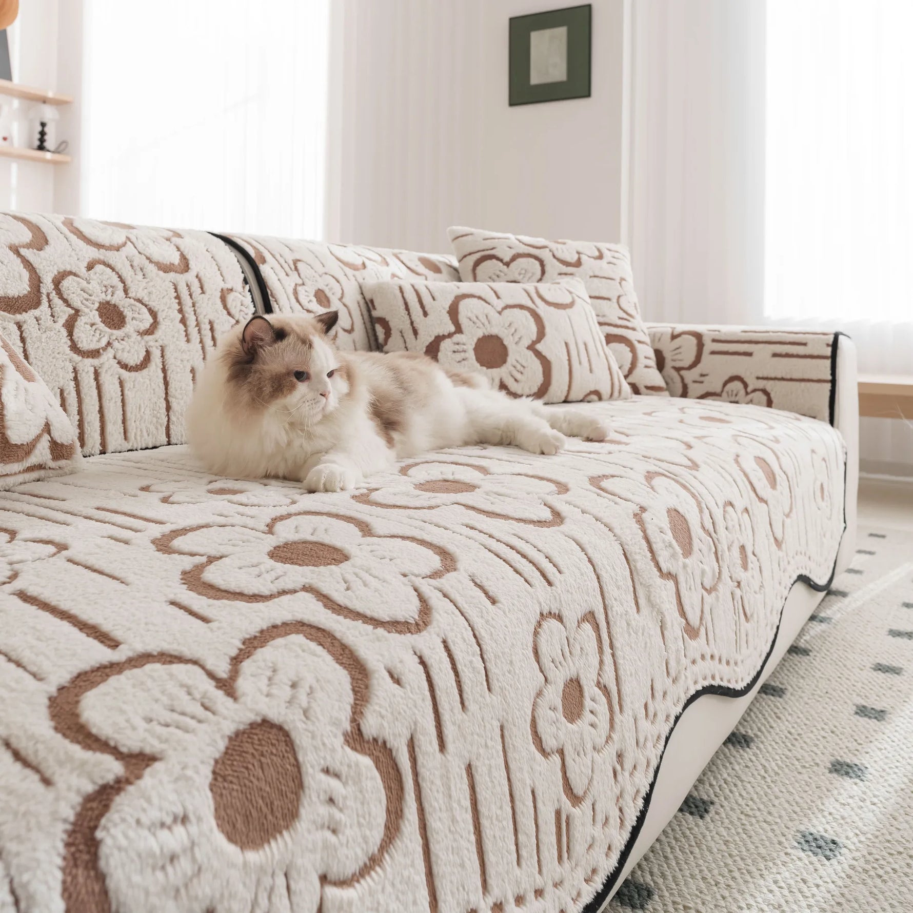 Un chat douillet est couché sur un canapé orné de motifs floraux.