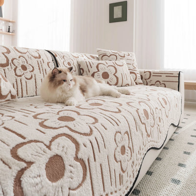 Un chat douillet est couché sur un canapé orné de motifs floraux.