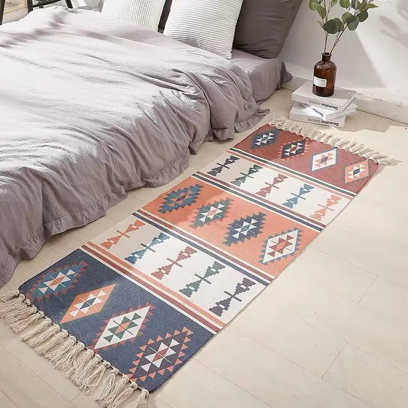 Un élégant tapis décoratif aux motifs géométriques colorés, posé sur le sol d'une chambre au style épuré, avec un lit confortable garni de draps gris.