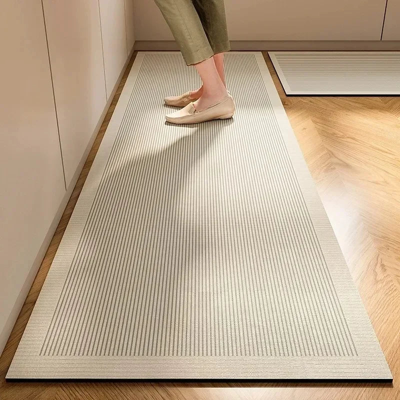 Un tapis rayé beige recouvre le sol d'une pièce, sur lequel se trouvent les pieds chaussés de mocassins d'une personne.